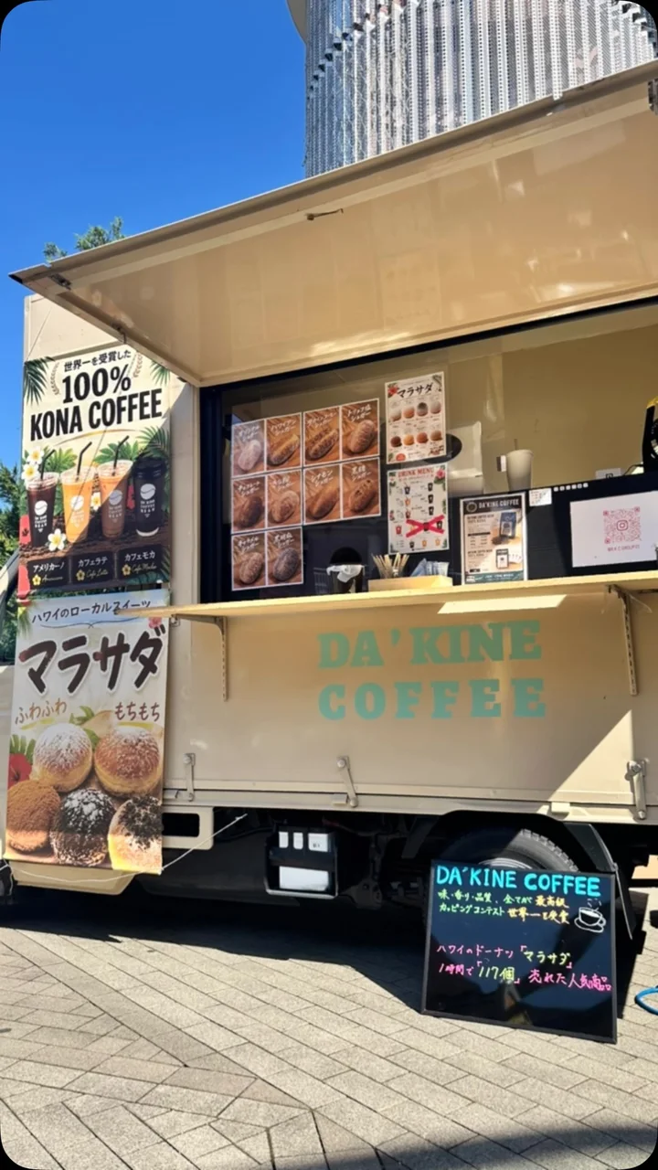 DA'KINE COFFEE BEANのキッチンカー。コナコーヒーとマラサダの看板が並ぶ販売窓口