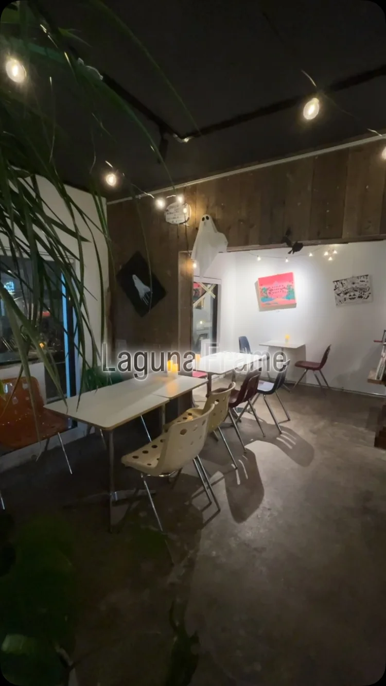 壁にアートが飾られ、テーブルと椅子が並ぶ駒沢本店の店内